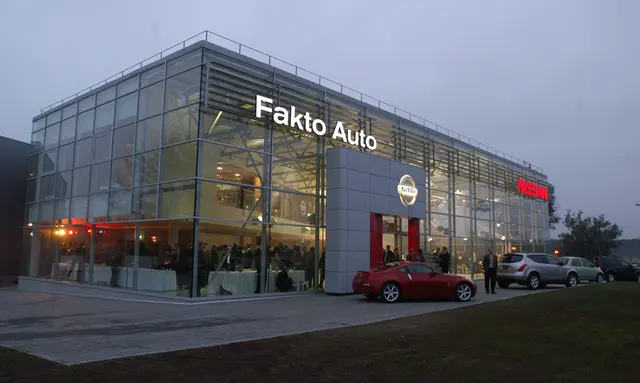 Nissan salonas — stiklinis automobilių salono fasadas vakare
